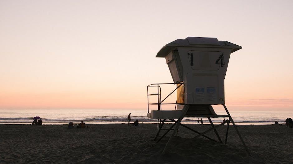 A picture of Del Mar Beach with a parking lot, restrooms and showers, and lifeguard towers.