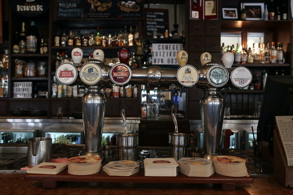 A brewery with various types of beer taps, with people sitting and enjoying their drinks.