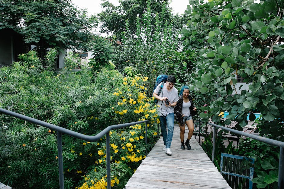 A couple walking through the lush gardens of Estancia La Jolla Hotel & Spa on a romantic getaway